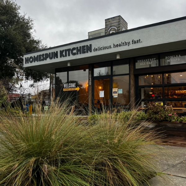 Standing outside of Homespun Kitchen Riverside looking at the building and sign that says delicious. healthy. fast.