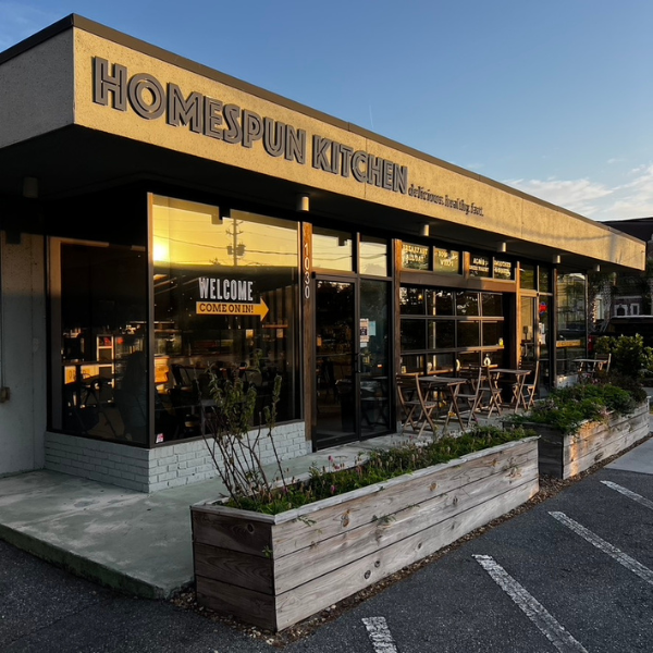 A view of Homespun Kitchen Riverside from Outside, looking at the main sign that says delicious. healthy. fast.